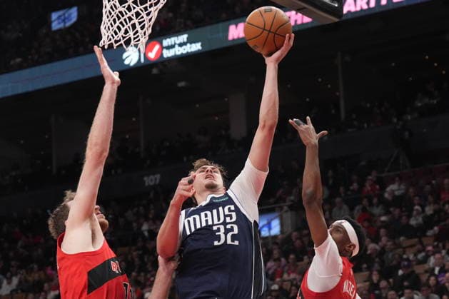 March 8, 2026, Toronto, On, CAN: Dallas Mavericks Cooper Flagg (32) goes for the lay up between Toronto Raptors Jakob Poeltl (19) and Ja kobe Walter (14) during half NBA, Basketball Herren, USA basketball action in Toronto on Sunday, March 8, 2026. Cooper Flagg; Jakob Poeltl; Ja Kobe Walter  - ZUMAc35_ 20260308_zaf_c35_141 Copyright: xChrisxYoungx