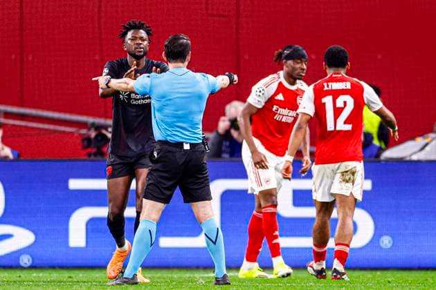 Referee Umut Meler is in discussion with Edmond Tapsoba of Bayer 04 Leverkusen after awarding a penalty to Arsenal FC Bayer 04 Leverkusen v Arsenal FC, UEFA Champions League 2025 26 Round of 16 First Leg, Bayer 04 Leverkusen v Arsenal FC, BayArena, March 11, 2026, Leverkusen, Germany.