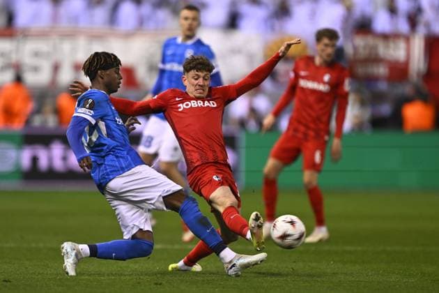 Genk s Noah Adedeji-Sternberg and Freiburg s Philipp Treu fight for the ball during a game between Belgian soccer team KRC Genk and German Freiburg, Thursday 12 March 2026 in Genk, the first leg of the 1 16 Finals of the UEFA Europa League tournament. JOHAN EYCKENS JohanxEyckens  x167297539x