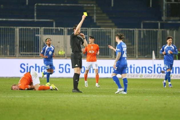 Magdeburg, Saxony-Anhalt, Germany, 13 03 2026 Avnet Arena 26 Matchday, Season 2025 26, 2 Soccer Bundesliga 1 FC Magdeburg Darmstadt 98 Referee Matthias Jöllenbeck shows the yellow card to Baris Atik 23, 1 FC Magdeburg , on the ground rolling in pain Isac Lidberg 7, SV Darmstadt 98 , in the scene also Rayan Ghrieb 29, 1 FC Magdeburg , Hiroki Akiyama 16, SV Darmstadt 98 and Laurin Ulrich 8, 1 FC Magdeburg Copyright: xdtsxNachrichtenagenturx dts_110637