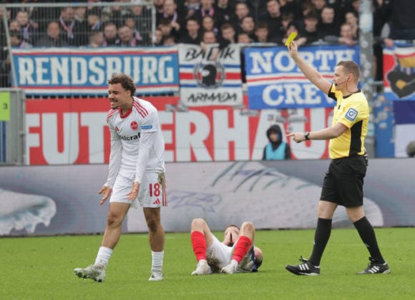 Referee Dr. Robert Kampka shows Rafael Lubach 1 FC Nuernberg the yellow card Football, Men, Season 2025 2026, 2 BL, Holstein Stadion, Holstein Kiel vs 1 FC Nuernberg, 2 3 DFL REGULATIONS PROHIBIT ANY USE OF PHOTOGRAPHS AS IMAGE SEQUENCES AND OR QUASI VIDEO