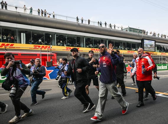 F1 Chinese Grand Prix 2026 SHANGHAI, CHINA - MARCH 15: Lewis Hamilton of Scuderia Ferrari HP runs and then poses for photographers in front of fans in the grandstand following the Drivers Parade ahead of the 2026 Chinese Grand Prix, at the Shanghai International Circuit, in Shanghai, China, on March 15, 2026. Shanghai China  Copyright: xArturxWidakx originalFilename:widak-f1chines260315_npSZE.jpg