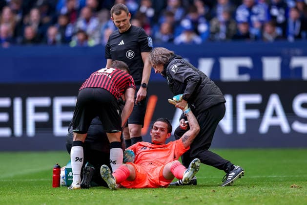 15 03 2026, Football, FC Schalke 04 Hannover 96, Matchday 26, 2 Fußball Bundesliga, Veltins Arena Gelsenkirchen, Season 2025 2026 Goalkeeper Nahuel Noll Hannover96 01 lies on the pitch in pain and needs medical attention DFB regulations prohibit any use of photographs as image sequences and or quasi video North Rhine-Westphalia Germany