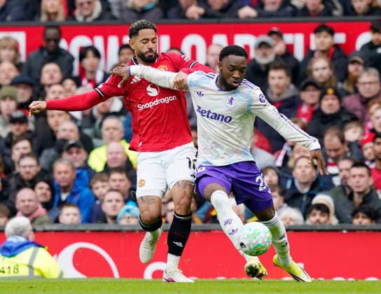 Manchester, England, 15th March 2026. Matheus Cunha of Manchester United, ManU challenges Lamare Bogarde of Aston Villa during the Manchester United vs Aston Villa Premier League match at Old Trafford, Manchester. Picture credit should read: Andrew Yates Sportimage EDITORIAL USE ONLY. No use with unauthorised audio, video, data, fixture lists, club league logos or live services. Online in-match use limited to 120 images, no video emulation. No use in betting, games or single club league player publications. SPI_038_AY_Man_Utd_Villa SPI-4605-0038