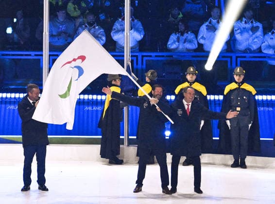 Milan Cortina Paralympics: Closing ceremony Representatives of the French Alps, the next winter Paralympic host region, wave the Paralympic flag after receiving it from International Paralympic Committee President Andrew Parsons (far L) during the closing ceremony of the Milan Cortina Paralympics at Cortina Curling Olympic Stadium on March 15, 2026, in Cortina d Ampezzo, Italy.  A14AA0005389336P