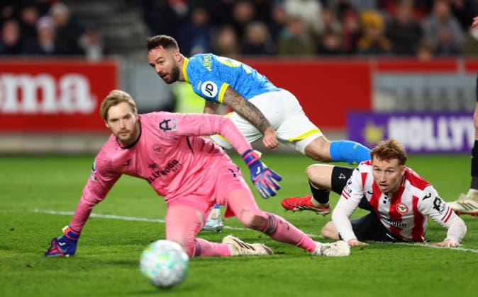 London, England, 16th March 2026. Adam Armstrong of Wolverhampton Wanderers watches as his shot misses the goal under pressure from Caoimhin Kelleher of Brentford and Sepp van den Berg of Brentford during the Brentford vs Wolverhampton Wanderers Premier League match at Gtech Community Stadium, London. Picture credit should read: Paul Terry Sportimage EDITORIAL USE ONLY. No use with unauthorised audio, video, data, fixture lists, club league logos or live services. Online in-match use limited to 120 images, no video emulation. No use in betting, games or single club league player publications. SPI_046_PT_Brentford_Wolves SPI-4606-0046