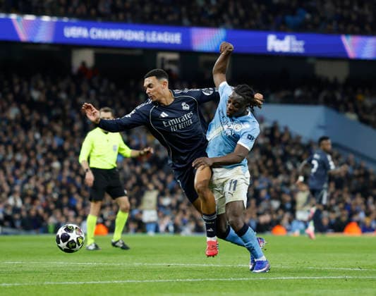 Manchester, England, 17th March 2026. Trent Alexander Arnold of Real Madrid tussles with Jeremy Doku of Manchester City during the Manchester City vs Real Madrid UEFA Champions League round of 16 match at the Etihad Stadium, Manchester. Picture credit should read: Cody Froggatt Sportimage EDITORIAL USE ONLY. No use with unauthorised audio, video, data, fixture lists, club league logos or live services. Online in-match use limited to 120 images, no video emulation. No use in betting, games or single club league player publications. SPI_049_CF_ManCity_Madrid SPI-4612-0103