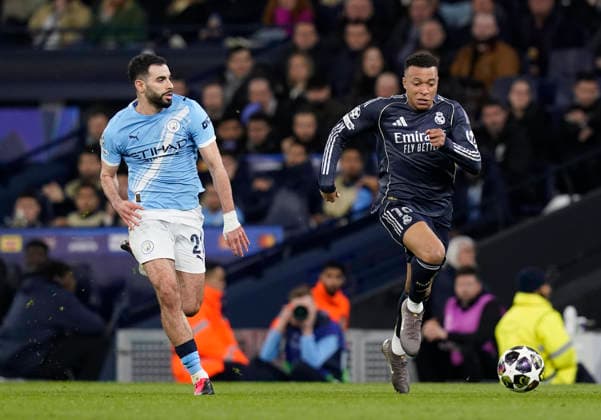 Manchester, England, 17th March 2026. Rayan Alt-Nouri of Manchester City (l) outpaced by Kylian Mbappe of Real Madrid during the Manchester City vs Real Madrid UEFA Champions League round of 16 match at the Etihad Stadium, Manchester. Picture credit should read: Andrew Yates Sportimage EDITORIAL USE ONLY. No use with unauthorised audio, video, data, fixture lists, club league logos or live services. Online in-match use limited to 120 images, no video emulation. No use in betting, games or single club league player publications. SPI_061_AY_ManCity_Madrid SPI-4612-0111