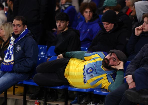 London, England, 17th March 2026. A Chelsea fan lays across seats during the Chelsea vs Paris Saint Germain UEFA Champions League round of 16 match at Stamford Bridge, London. Picture credit should read: Paul Terry Sportimage EDITORIAL USE ONLY. No use with unauthorised audio, video, data, fixture lists, club league logos or live services. Online in-match use limited to 120 images, no video emulation. No use in betting, games or single club league player publications. SPI_070_PT_Chelsea_PSG SPI-4610-0069