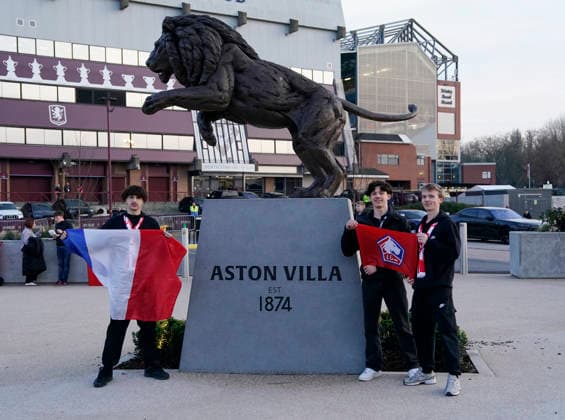Birmingham, England, 19th March 2026. Lille fans pose by the lion statue outside the stadium during the Aston Villa vs LOSC Lille UEFA Europa League round of 16 match at Villa Park, Birmingham. Picture credit should read: Andrew Yates Sportimage EDITORIAL USE ONLY. No use with unauthorised audio, video, data, fixture lists, club league logos or live services. Online in-match use limited to 120 images, no video emulation. No use in betting, games or single club league player publications. SPI_002_AY_Villa_Lille SPI-4627-0002