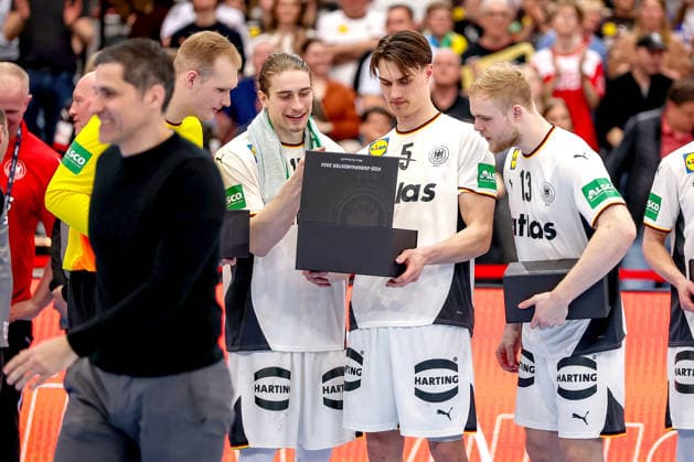 19 03 2026, Handball, Mens international match, Germany Egypt, Westfalenhalle Dortmund Impressions of the award ceremony for the 2026 European Championship runners-up after the match The players are honored for second place at the European Championship David Späth Germany 01 Juri Knorr Germany 15 Miro Schluroff Germany 05 Matthes Langhoff Germany 13 look curiously into the gift box from Ingo Meckes North Rhine-Westphalia Germany