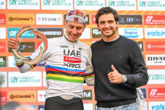 Slovenian Tadej Pogacar and racing driver Carlos Sainz pictured on the podium after the Milano-Sanremo one day cycling race for men, 298km from Milan to San Remo, Italy, Saturday 21 March 2026. DAVIDxPINTENS  x168481490x