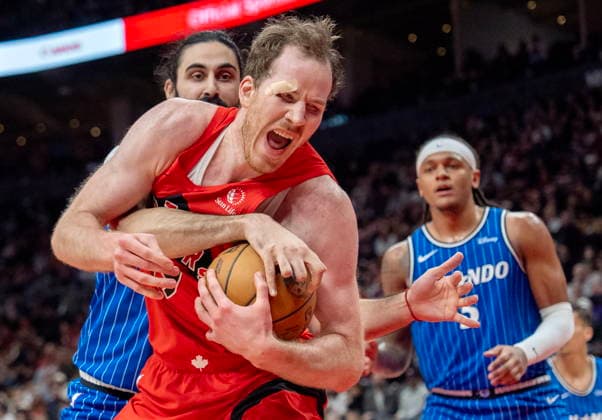 March 29, 2026, Toronto, On, Canada: Toronto Raptors centre Jakob Poeltl (front) is fouled by Orlando Magic centre Goga Bitadze (back left) as Magic forward Paolo Banchero (right) looks on during first half NBA, Basketball Herren, USA action in Toronto on Sunday, March 29, 2026. Canada News - March 29, 2026  - ZUMAc35_ 20260329_zaf_c35_184 Copyright: xFrankxGunnx