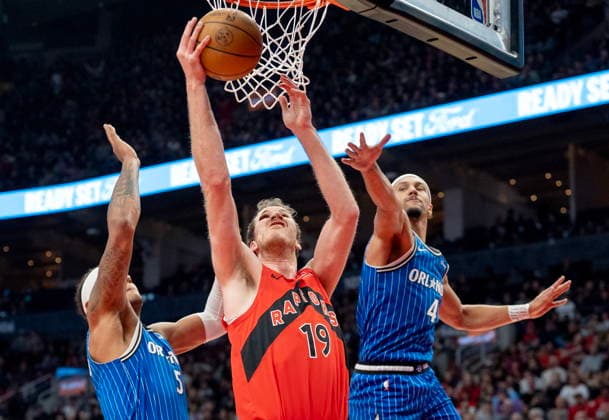 March 29, 2026, Toronto, On, Canada: Toronto Raptors centre Jakob Poeltl (19) drives to the hoop past Orlando Magic guard Jalen Suggs (4) and forward Paolo Banchero (5) during first half NBA, Basketball Herren, USA action in Toronto on Sunday, March 29, 2026. Canada News - March 29, 2026  - ZUMAc35_ 20260329_zaf_c35_182 Copyright: xFrankxGunnx