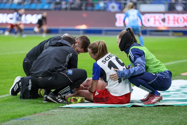 from left Victoria Schulz Hamburger SV, HSV, 19 sits injured on the ground, injury, pain, distorted face, Emilia Hirche Hamburger SV, HSV, 20 takes care of her, THE DFB REGULATIONS PROHIBIT ANY USE OF PHOTOGRAPHS AS IMAGE SEQUENCES AND OR QUASI VIDEO , 30 03 2026, Hamburg Germany , Football, Google Pixel Womens Bundesliga, Hamburger SV Bayer 04 Leverkusen xobx