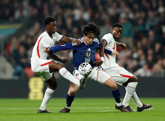 London, England, 31st March 2026. Kobbie Mainoo of England (l) and Marc Guehi of England (r) tackle Ayase Ueda of Japan (c) during the England vs Japan International Friendly, Länderspiel, Nationalmannschaft match at Wembley Stadium, London. Picture credit should read: Matthew Impey Sportimage EDITORIAL USE ONLY. No use with unauthorised audio, video, data, fixture lists, club league logos or live services. Online in-match use limited to 120 images, no video emulation. No use in betting, games or single club league player publications. SPI_033_MI_Eng_Japan SPI-4662-0032