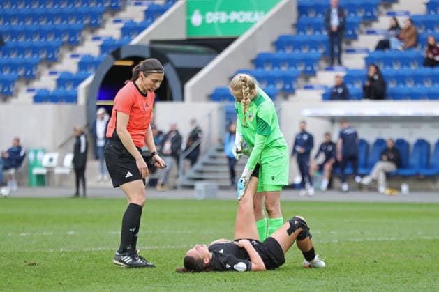 DFB Pokal Frauen FC Carl Zeiss Jena VfL Wolfsburg 05 04 26 Nelly Juckel 31, Carl Zeiss Jena lies on the ground with a cramp and is attended to by goalkeeper Jasmin Janning 1, Carl Zeiss Jena Referee Angelika Söder inquires soccer, DFB Cup Women, semi-final FC Carl Zeiss Jena vs VfL Wolfsburg on 05 04 26 at Ernst Abbe Sportfeld ad hoc arena, Jena DFL REGULATIONS PROHIBIT ANY USE OF PHOTOGRAPHS AS IMAGE SEQUENCES AND OR QUASI VIDEO Copyright: xBEAUTIFULxSPORTS JanxKaeferx