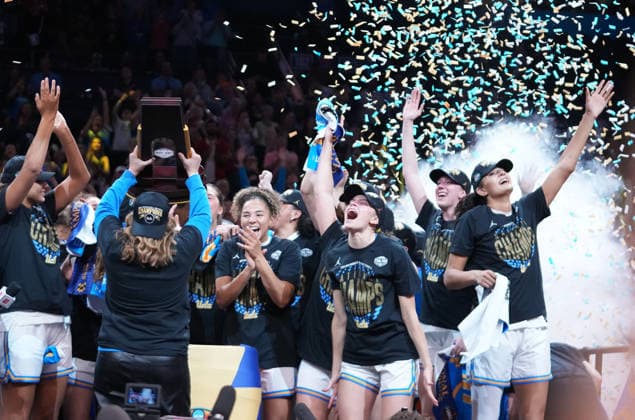 UCLA head coach Cori Close raises the trophy as players celebrate after defeating South Carolina in the Finals of the 2026 NCAA, College League, USA Women s Basketball Tournament at Mortgage Matchup Center in Phoenix, Arizona, on Sunday, April 5, 2026. UCLA defeated South Carolina 79-51 to win their first-ever women s NCAA Tournament championship.  AZP20260405973 DARRYLxWEBB