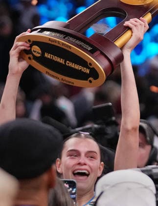 UCLA forward Gabriela Jaquez (11) raises the trophy in celebration after the Bruins defeated South Carolina in the Finals of the 2026 NCAA, College League, USA Women s Basketball Tournament at Mortgage Matchup Center in Phoenix, Arizona, on Sunday, April 5, 2026. UCLA defeated South Carolina 79-51 to win their first-ever women s NCAA Tournament championship.  AZP20260405977 DARRYLxWEBB