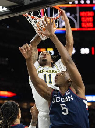 April 6, 2026, Indianapolis, Indiana, USA: Michigans Roddy Gayle Jr dunks over UConns Tarris Reed Jr during first half action of the NCAA, College League, USA Mens Basketball Championship. Michigan went on to win 69-63. Monday, April 7, 2026. Indianapolis USA - ZUMAr44_ 20260406_zsp_r44_014 Copyright: xThomasxJ.xRussox