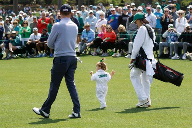 Justin Thomas, his wife Jillian Thomas and their daughter Molly Grace Thomas walk down a fairway as they take part in the 2026 Masters golf tournament Par 3 Contest at Augusta National Golf Club in Augusta, Georgia, on Wednesday, April 8, 2026. The 2026 Masters Golf tournament begins on Thursday, April 9.  AUG20260408826 JOHNxANGELILLO