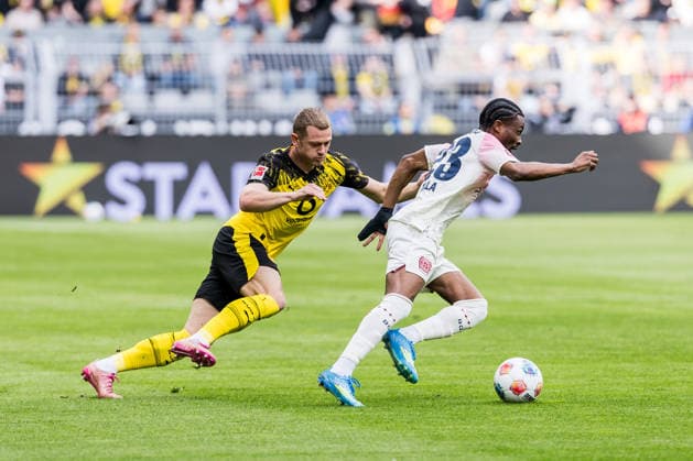 DORTMUND, GERMANY - APRIL 11: Nathan Tella (Bayer 04 Leverkusen, 23) controls the ball against Julian Ryerson (Borussia Dortmund, 26) during the Bundesliga match between Borussia Dortmund vs. Bayer 04 Leverkusen at Signal Iduna Park on matchday 29 of the 1. Bundesliga on April 11, 2026 in Dortmund, Germany. DFL REGULATIONS PROHIBIT ANY USE OF PHOTOGRAPHS AS IMAGE SEQUENCES AND OR QUASI-VIDEO. North Rhine Westphalia Germany Copyright: xSteffiexWunderlx