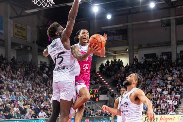 Jalen Finch 0 Telekom Baskets Bonn tries the basket while 45 Basketball Lions Braunschweig and 24 Basketball Lions Braunschweig defend EasyCredit BBL league game on matchday 29 in Bonn between Telekom Baskets Bonn and Basketball Lions Braunschweig Basket shot by Jalen Finch 0 Telekom Baskets Bonn against 45 Basketball Lions Braunschweig and 24 Basketball Lions Braunschweig Copyright: xFeyzullahxGökalp feyzofsportsx