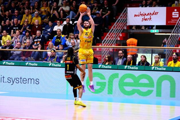 ProA Phoenix Hagen vs Bozic Estriche Knights Kirchheim, Hagen, 12 04 2026, Ischelandhalle Hagen Tim Uhlemann 21, Phoenix Hagen, PF on a three-pointer, defended by Phillip Montreal Russell 1, Bozic Estriche Knights Kirchheim, PG ProA Phoenix Hagen vs Bozic Estriche Knights Kirchheim, Hagen, 12 04 2026, Ischelandhalle Hagen Copyright: xBEAUTIFULxSPORTS Piepenstockx