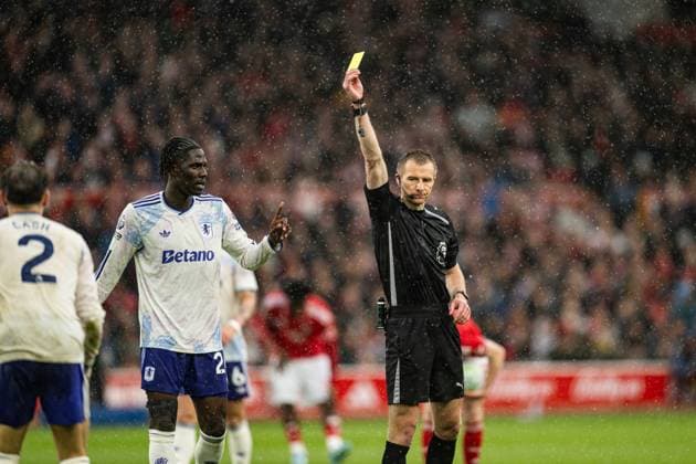 12th April 2026; The City Ground, Nottingham, England; Premier League Football, Nottingham Forest versus Aston Villa; Referee Michael Salisbury issues a yellow card to Matty Cash of Aston Villa GodfreyxPitt