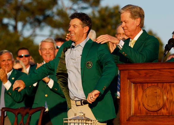 Rory McIlroy of Northern Ireland is presented with his green jacket by Chairman of Augusta National Golf Club Fred Ridley (R) after winning the 2026 Masters Tournament at Augusta National Golf Club on Sunday, April 12, 2026, in Augusta, Georgia. McIlroy won his second consecutive Masters with a 12-under-par four-day score of 276.  AUG202604128894 JOHNxANGELILLO