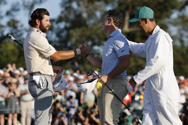 Golf - Masters Tournament round 4 Rory McIlroy of Northern Ireland (C) and his caddie Harry Diamond (R) greet Cameron Young of the US after putting through on the 18th green as McIlroy wins the 2026 Masters tournament in Augusta, Georgia, USA, 12 April 2026. AUGUSTA GEORGIA United States  Copyright: xERIKxS.xLESSERx