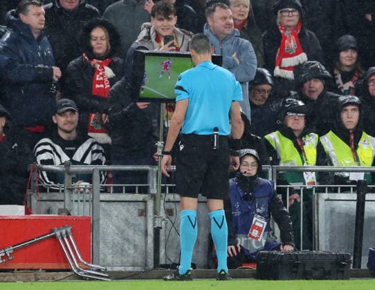 Liverpool, England, 14th April 2026. Referee Maurizio Mariani views a replay on the VAR screen before reversing his decision to awardLiverpool a penalty during the Liverpool vs Paris Saint Germain UEFA Champions League quarter final 2nd leg match at Anfield, Liverpool. Picture credit should read: Jessica Hornby Sportimage EDITORIAL USE ONLY. No use with unauthorised audio, video, data, fixture lists, club league logos or live services. Online in-match use limited to 120 images, no video emulation. No use in betting, games or single club league player publications. SPI_093_JH_Liverpool_PSG SPI-4687-0093