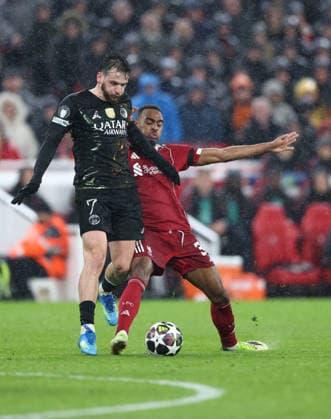 Liverpool, England, 14th April 2026. Khvicha Kvaratskhelia of Paris Saint-Germain (l) tackled by Ryan Gravenberch of Liverpool (r) during the Liverpool vs Paris Saint Germain UEFA Champions League quarter final 2nd leg match at Anfield, Liverpool. Picture credit should read: Jessica Hornby Sportimage EDITORIAL USE ONLY. No use with unauthorised audio, video, data, fixture lists, club league logos or live services. Online in-match use limited to 120 images, no video emulation. No use in betting, games or single club league player publications. SPI_103_JH_Liverpool_PSG SPI-4687-0103
