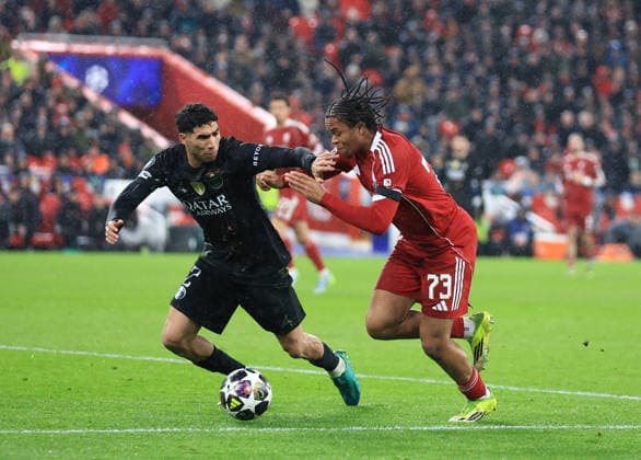 Liverpool, England, 14th April 2026. Achraf Hakimi of Paris Saint-Germain tackles Rio Ngumoha of Liverpool during the Liverpool vs Paris Saint Germain UEFA Champions League quarter final 2nd leg match at Anfield, Liverpool. Picture credit should read: Jessica Hornby Sportimage EDITORIAL USE ONLY. No use with unauthorised audio, video, data, fixture lists, club league logos or live services. Online in-match use limited to 120 images, no video emulation. No use in betting, games or single club league player publications. SPI_107_JH_Liverpool_PSG SPI-4687-0107