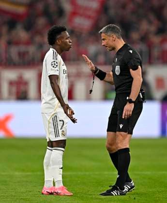 15 04 2026, Football UEFA Championsleague 2025 2026 quarter-final second leg, FC Bayern Munich Real Madrid, at Allianz Arena Munich, referee Slavko Vicic Slovenia speaks with Vinicius Junior Real Madrid DFL and DFB regulations prohibit any use of photographs as image sequences and or quasi video