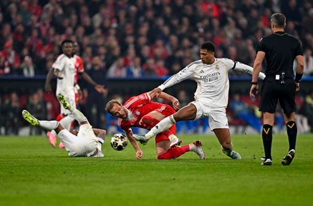 15 04 2026, Football UEFA Championsleague 2025 2026 quarter-final second leg, FC Bayern Munich Real Madrid, in the Allianz Arena Munich, Harry Kane FC Bayern Munich on the ground against Jude Bellingham Real Madrid DFL and DFB regulations prohibit any use of photographs as image sequences and or quasi video
