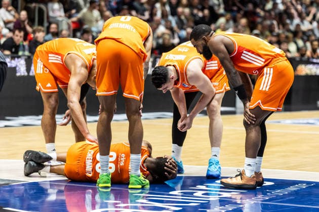 GER, easy Credit Basketball Bundesliga, 23 Spieltag, Niners Chemnitz Ratiopharm Ulm 15 04 2026, Messe, Chemnitz, GER, easy Credit Basketball Bundesliga, 23 Spieltag, Niners Chemnitz Ratiopharm Ulm Eric Washington Niners Chemnitz, 33 on the ground surrounded by his teammates Photo Alexander Trienitz Chemnitz Messe Sachsen Germany