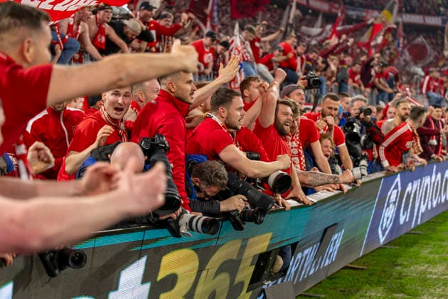 15 04 2026, Football UEFA Champions League 2025 2026 quarter-final second leg, FC Bayern Munich Real Madrid, in the Allianz Arena Munich, fans storm the interior before the final whistle and push over the boards with the photographers while celebrating the goal, two photographers are injured, even unconscious, and have to be treated by a doctor afterwards