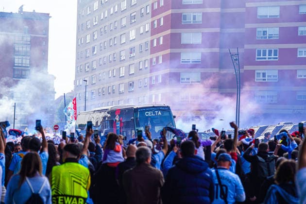 Spain football UEFA Europa League 2025 2026, quarter-final second leg Celta Vigo vs SC Freiburg Balaidos Vigo team bus, team bus, Celta Vigo, club logo, CELTA lettering, arrival team, match day, UEFA Europa League, fans, spectators, crowd, crowds, cheering, enthusiasm, flags, club colors, blue, fan merchandise, smartphones, photos, media interest, atmosphere, pyrotechnics, smoke, police, security forces, stewards, escort, road traffic, urban environment, residential building in the background Copyright: xJOERANxSTEINSIEKx