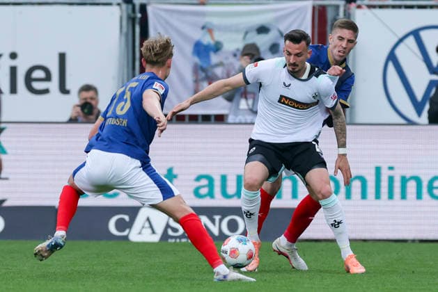 Kasper Davidsen Holstein Kiel , Mergim Berisha 1 FC Kaiserslautern and David Zec Holstein Kiel battle for the ball, 2 Bundesliga, Holstein Kiel v 1 FC Kaiserslautern, Holstein Stadion on April 17, 2026 in Kiel, Germany Photo by Marco Steinbrenner DeFodi Images Kasper Davidsen Holstein Kiel , Mergim Berisha 1 FC Kaiserslautern and David Zec Holstein Kiel battle for the ball, 2 Bundesliga, Holstein Kiel v 1 FC Kaiserslautern, Holstein Stadion, April 17, 2026 in Kiel, Germany Photo by Marco Steinbrenner DeFodi Images