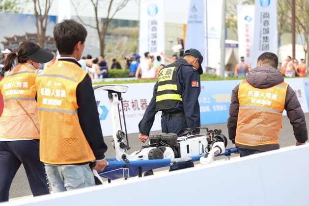 BEIJING, CHINA - APRIL 19: Staff members carry the fallen humanoid robot away on a stretcher in the 2026 Beijing E-Town Humanoid Robot Half-marathon on April 19, 2026 in Beijing, China. A remotely controlled Lightning robot from one Honor team was the first to cross the finish line, clocking 48 minutes and 19 seconds, according to China Media Group (CMG). Based on the event s weighting rules, another robot from Honor s autonomous navigation team won the championship with a net time of 50 minutes and 26 seconds.  Copyright: xChinaxNewsxServicex 111635811766
