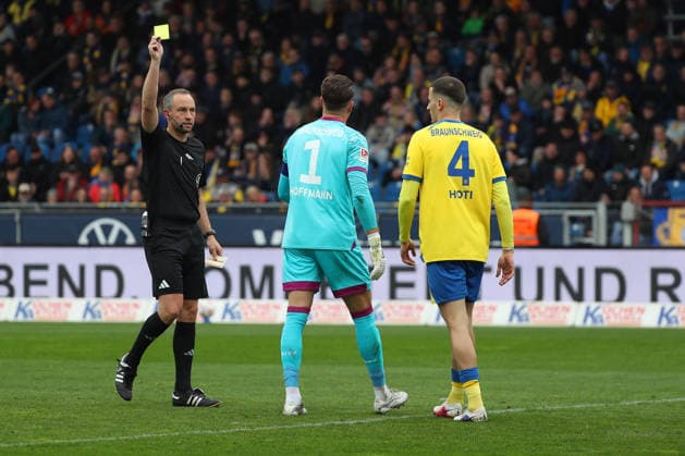 19 04 2026, Football, Men, 2 BL, Season 2025 2026, Eintracht Braunschweig vs Hertha BSC Berlin Referee shows goalkeeper Ron Thorben Hoffmann Eintracht Braunschweig the yellow card DFL DFB REGULATIONS PROHIBIT ANY USE OF PHOTOGRAPHS as IMAGE SEQUENCES and or QUASI VIDEO Stadion an der Hamburger Straße Niedersachsen Germany