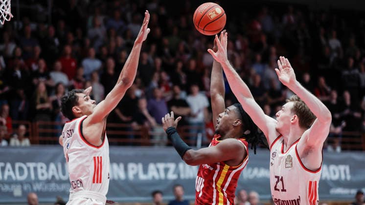 In the picture Oscar da Silva FC Bayern Muenchen Basketball, 1 , left in the picture and Justus Hollatz FC Bayern Muenchen Basketball, 21 , right against Marcus Carr Wuerzburg Baskets, 5 on the ball 23 04 2026, Basketball, Fitness First Wuerzburg Baskets vs FC Bayern Muenchen Basketball, easyCredit BBL, 26 Matchday, Germany, 97072, tectake Arena Wuerzburg, Copyright: HMBxMedia xJulienxBecker