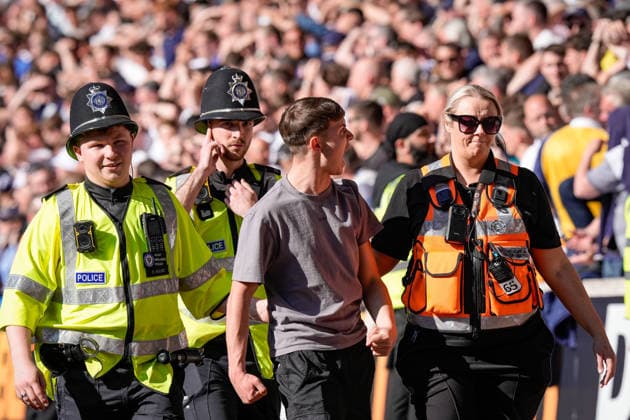 Wolverhampton Wanderers v Tottenham Hotspur - Premier League A fan is escorted and removed from the ground by police for attempting to enter the field of play during the Premier League match between Wolverhampton Wanderers and Tottenham Hotspur at Molineux in Wolverhampton, United Kingdom, on April 25, 2026. Wolverhampton West Midlands United Kingdom  Copyright: xNewsxImagesx originalFilename:cosgrove-premierl260425_npjul.jpg