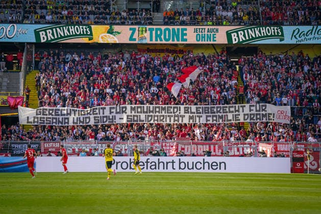 Sport Bilder des Tages Deutschland: Fussball Bundesliga 2025 - 2026, 31. Spieltag - BVB Borussia Dortmund vs SC Freiburg - Signal-Iduna-Park (Dortmund): SC Freiburg Fans, Gästeblock, Auswärtsfans, Protestbanner, Gerechtigkeit für Mouhamed, Bleiberecht, Solidarität, Fankurve, Ultra-Szene, politisches Statement, Fanprotest, Stadionbanner, Fußball und Gesellschaft, Signal Iduna Park, Bundesliga, Borussia Dortmund vs SC Freiburg, Brinkhoff™s, Vodafone, Werbebanden, Sponsorenbranding, Tribüne, Supporters, Fußballkultur, Medienmotiv *** Germany Soccer Bundesliga 2025 2026, 31 Matchday BVB Borussia Dortmund vs SC Freiburg Signal Iduna Park Dortmund SC Freiburg Fans, Guest Block, Away Fans, Protest Banner, Justice for Mouhamed, Right to Stay, Solidarity, Fan Curve, Ultra Scene, political statement, fan protest, stadium banner, soccer and society, Signal Iduna Park, Bundesliga, Borussia Dortmund vs SC Freiburg, Brinkhoff™s, Vodafone, advertising boards, sponsor branding, grandstand, supporters, soccer culture, media motif Copyright: xJOERANxSTEINSIEKx