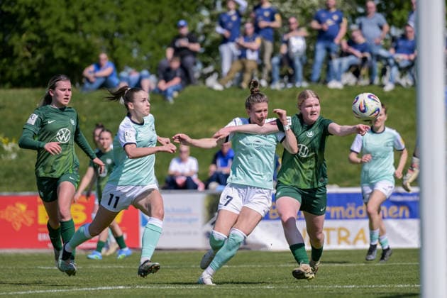 26 04 2026, Football, 2 Womens Bundesliga, 2025 2026, Matchday 23, SG 99 Andernach VfL Wolfsburg II Freyja Landrö Wolfsburg holds Carolin Schraa 7 Andernach back with her arm by the neck Andernach Stadium Rhineland-Palatinate Germany
