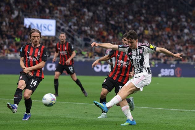 Milan, Italy, 26th April 2026. Andrea Cambiaso of Juventus fires an effort goalwards as Luka Modric of AC Milan attempts to make a block during the AC Milan vs Juventus Serie A match at Giuseppe Meazza, Milan. Picture credit should read: Jonathan Moscrop Sportimage EDITORIAL USE ONLY. No use with unauthorised audio, video, data, fixture lists, club league logos or live services. Online in-match use limited to 120 images, no video emulation. No use in betting, games or single club league player publications. SPI_049_JM_MILAN_JUVE SPI-4695-0049
