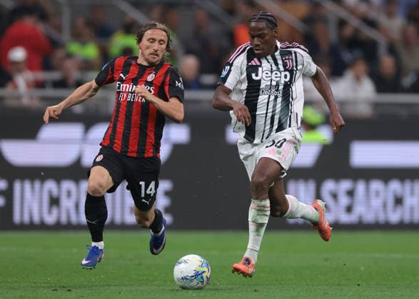 Milan, Italy, 26th April 2026. Jonathan David of Juventus takes on Luka Modric of AC Milan during the AC Milan vs Juventus Serie A match at Giuseppe Meazza, Milan. Picture credit should read: Jonathan Moscrop Sportimage EDITORIAL USE ONLY. No use with unauthorised audio, video, data, fixture lists, club league logos or live services. Online in-match use limited to 120 images, no video emulation. No use in betting, games or single club league player publications. SPI_101_JM_MILAN_JUVE SPI-4695-0101