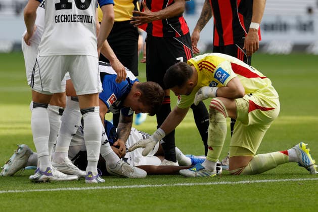 v.l.n.r. Luka Vuskovic (Hamburger SV) und Torwart Daniel Heuer Fernandes (Hamburger SV) kümmern sich um den verletzt, verletzung, injury, Jordan Torunarigha (Hamburger SV), im Bundesliga-Spiel zwischen Eintracht Frankfurt und dem Hamburger SV in der Deutsche Bank Park, Frankfurt am Main, Deutschland, am 2. Mai 2026. in action during the Bundesliga match between Eintracht Frankfurt and Hamburger SV at the Deutsche Bank Park, Frankfurt, Germany, on May 2, 2026. DFB DFL REGULATIONS PROHIBIT ANY USE OF PHOTOGRAPHS AS IMAGE SEQUENCES AND OR QUASI-VIDEO, *** from left to right Luka Vuskovic Hamburger SV and goalkeeper Daniel Heuer Fernandes Hamburger SV take care of the injured, injury, injury, Jordan Torunarigha Hamburger SV , in the Bundesliga match between Eintracht Frankfurt and Hamburger SV at the Deutsche Bank Park, Frankfurt am Main, Germany, on May 2, 2026 in action during the Bundesliga match between Eintracht Frankfurt and Hamburger SV at the Deutsche Bank Park, Frankfurt, Germany, on May 2, 2026 DFB DFL REGULATIONS PROHIBIT ANY USE OF PHOTOGRAPHS AS IMAGE SEQUENCES AND OR QUASI VIDEO, Copyright: HMBxMedia xHeikoxBecker