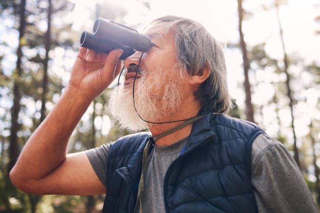 Hiking, binoculars and senior man in nature looking at view, sightseeing or watching. Binocular, adventure and elderly male with field glasses, trekking or exploring on holiday or vacation outdoors (License=RF) 19845685 ,model released, Symbolfoto  Copyright: xZoonar.com YurixArcursxpeopleimages.comx 19845685 ,model released, Symbolfoto ,property released